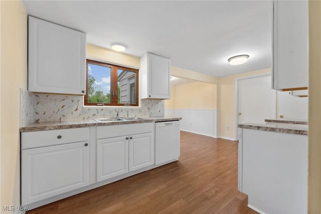 6525 Wales Ave NW, Massillon, OH 44646 - kitchen with white dishwasher, a sink, tasteful backsplash, wood finished floors, and white cabinets