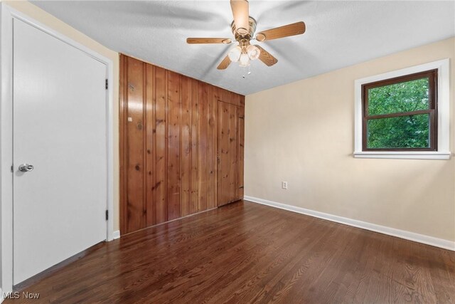 6525 Wales Ave NW, Massillon, OH 44646 - unfurnished bedroom featuring wood finished floors, baseboards, and ceiling fan