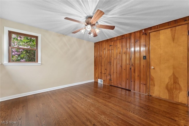 6525 Wales Ave NW, Massillon, OH 44646 - spare room with a ceiling fan, wood finished floors, baseboards, and wooden walls