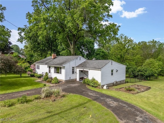 6525 Wales Ave NW, Massillon, OH 44646 - view of front of house featuring driveway, a chimney, and a shingled roof