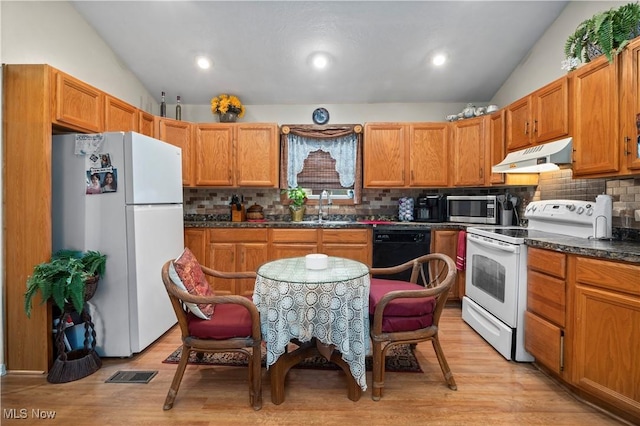 6610 Lear Nagle Rd Unit 26, North Ridgeville, OH 44039 - kitchen with white appliances, under cabinet range hood, vaulted ceiling, a sink, and dark countertops