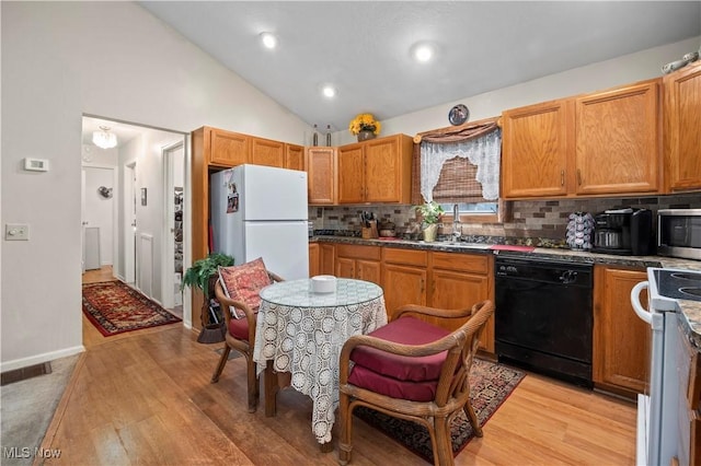 6610 Lear Nagle Rd Unit 26, North Ridgeville, OH 44039 - kitchen with white appliances, light wood-style floors, decorative backsplash, a sink, and dark countertops