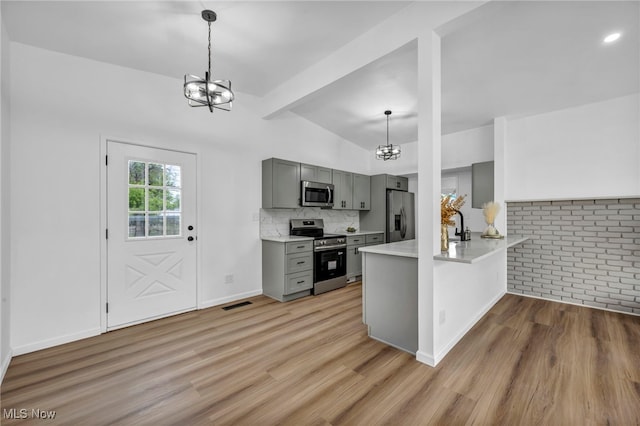 6482 Sherborn Rd, Parma Heights, OH 44130 - kitchen with appliances with stainless steel finishes, a chandelier, gray cabinetry, light wood-type flooring, and light countertops