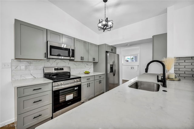6482 Sherborn Rd, Parma Heights, OH 44130 - kitchen featuring appliances with stainless steel finishes, a sink, gray cabinetry, a chandelier, and tasteful backsplash