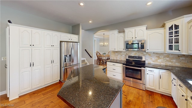 3130 Hollybrook Ln, Mogadore, OH 44260 - kitchen featuring appliances with stainless steel finishes, backsplash, glass insert cabinets, recessed lighting, and dark stone counters