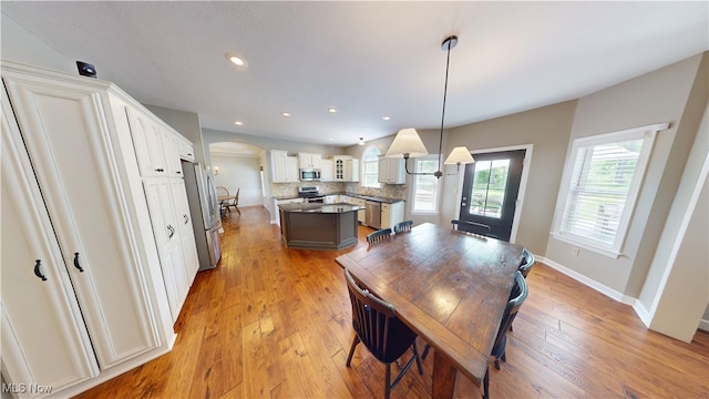 3130 Hollybrook Ln, Mogadore, OH 44260 - dining area with arched walkways, light wood-style flooring, recessed lighting, and baseboards