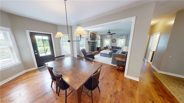 3130 Hollybrook Ln, Mogadore, OH 44260 - dining room with a fireplace, hardwood / wood-style flooring, a ceiling fan, and baseboards