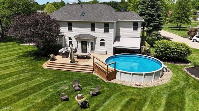 3130 Hollybrook Ln, Mogadore, OH 44260 - rear view of property featuring a deck, an outdoor pool, and a lawn