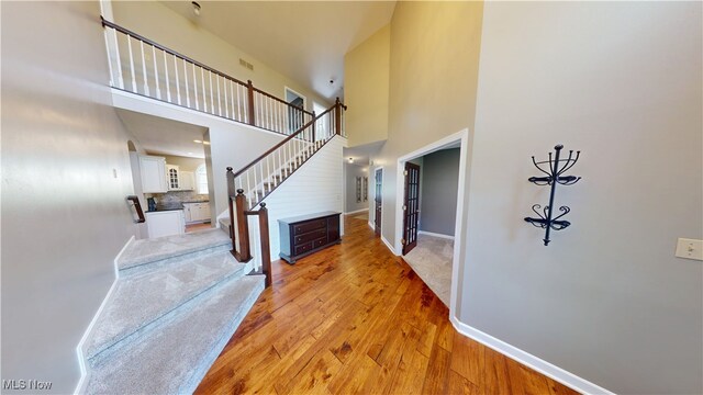 3130 Hollybrook Ln, Mogadore, OH 44260 - entrance foyer with stairs, a high ceiling, light wood finished floors, and baseboards