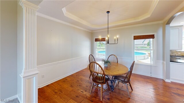 3130 Hollybrook Ln, Mogadore, OH 44260 - dining area featuring a tray ceiling, arched walkways, wood-type flooring, a chandelier, and crown molding