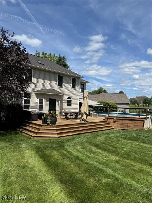 3130 Hollybrook Ln, Mogadore, OH 44260 - back of house featuring an outdoor pool, a deck, and a lawn