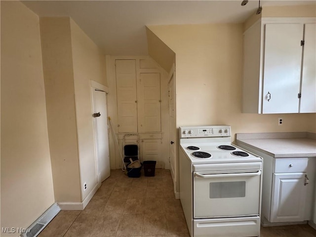 1733 E 47th St, Ashtabula, OH 44004 - kitchen featuring white electric stove, white cabinets, light countertops, light tile patterned floors, and baseboards