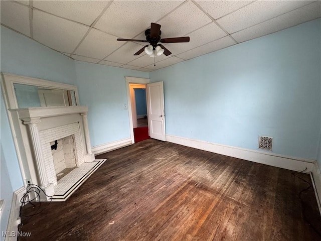 1733 E 47th St, Ashtabula, OH 44004 - unfurnished living room with a ceiling fan, wood finished floors, a drop ceiling, baseboards, and a fireplace