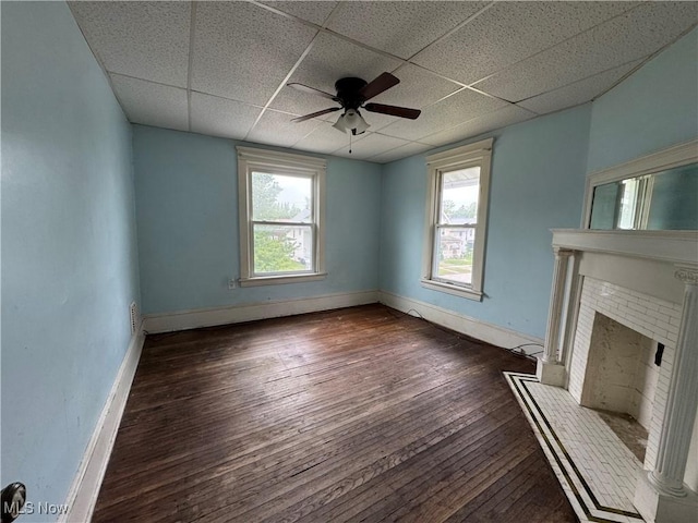 1733 E 47th St, Ashtabula, OH 44004 - unfurnished living room with hardwood / wood-style flooring, a drop ceiling, a brick fireplace, ceiling fan, and baseboards
