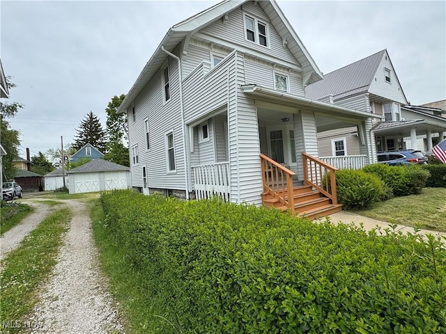 1733 E 47th St, Ashtabula, OH 44004 - view of front of home with covered porch and a detached garage