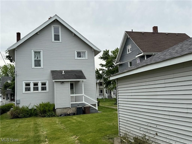 1733 E 47th St, Ashtabula, OH 44004 - back of house with a lawn and a chimney