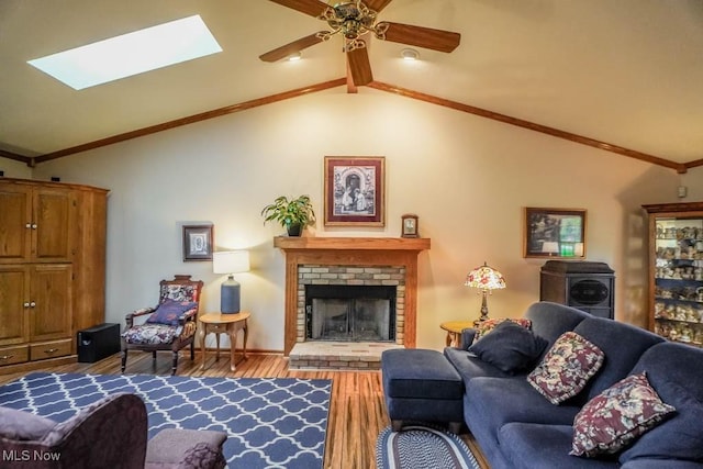 1632 Schneider St NW, North Canton, OH 44720 - living room with vaulted ceiling, wood finished floors, a skylight, a fireplace, and a ceiling fan
