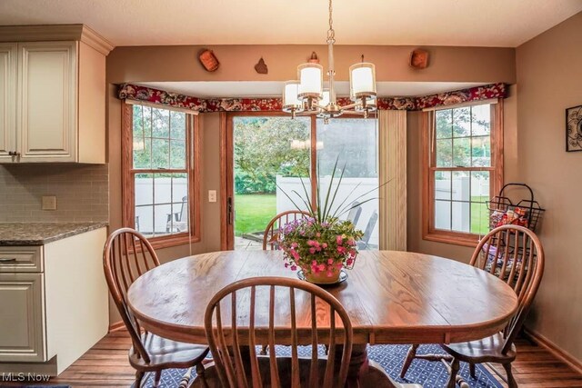 1632 Schneider St NW, North Canton, OH 44720 - dining room featuring wood finished floors, a chandelier, and baseboards