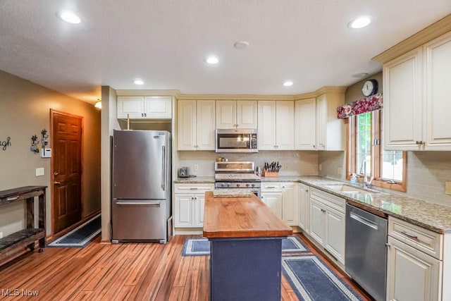 1632 Schneider St NW, North Canton, OH 44720 - kitchen with stainless steel appliances, butcher block counters, a sink, light wood-style flooring, and recessed lighting