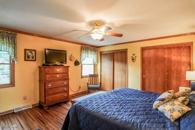 1632 Schneider St NW, North Canton, OH 44720 - bedroom with hardwood / wood-style floors, multiple closets, baseboards, ornamental molding, and ceiling fan