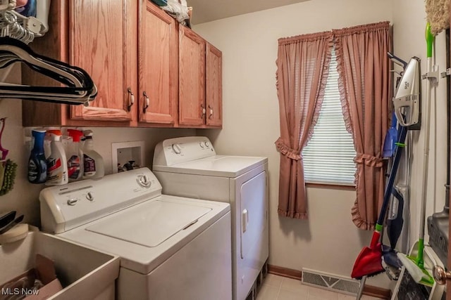 1632 Schneider St NW, North Canton, OH 44720 - washroom featuring washer and clothes dryer, cabinet space, light tile patterned flooring, and baseboards
