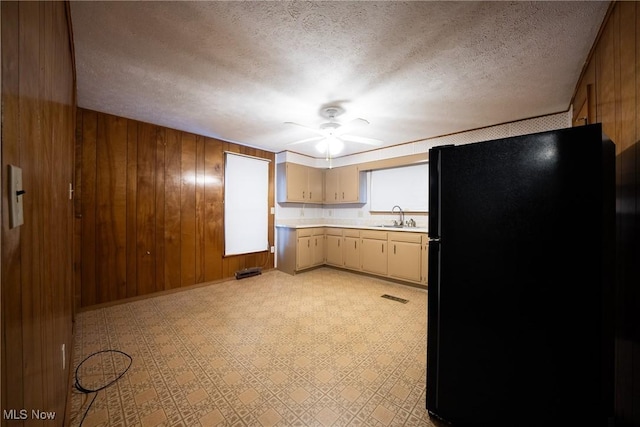 113 Lincoln Ct, Elyria, OH 44035 - kitchen with freestanding refrigerator, a sink, light countertops, a textured ceiling, and wood walls