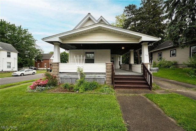 113 Lincoln Ct, Elyria, OH 44035 - shotgun-style home featuring covered porch and a front lawn