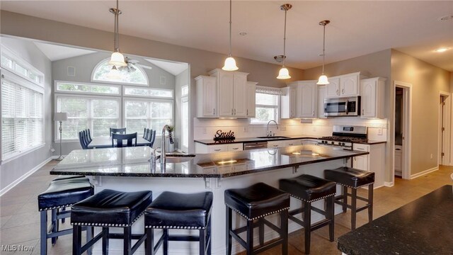 284 Kaylee Dr, Wadsworth, OH 44281 - kitchen with appliances with stainless steel finishes, a sink, white cabinetry, backsplash, and lofted ceiling