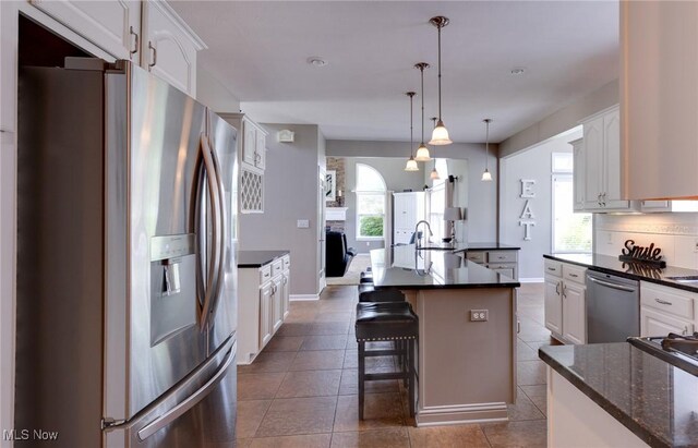 284 Kaylee Dr, Wadsworth, OH 44281 - kitchen featuring appliances with stainless steel finishes, a kitchen island with sink, white cabinetry, and plenty of natural light
