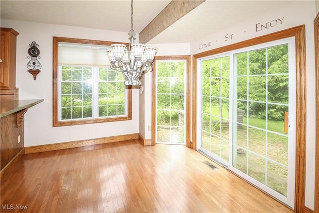 5280 Kapok Dr, Medina, OH 44256 - unfurnished dining area with baseboards, light wood-type flooring, and a chandelier