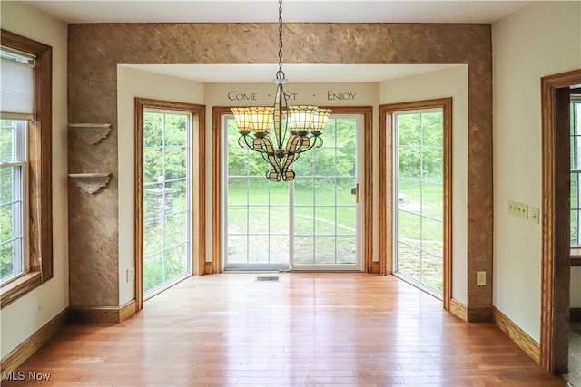 5280 Kapok Dr, Medina, OH 44256 - unfurnished dining area with hardwood / wood-style floors, a chandelier, and plenty of natural light