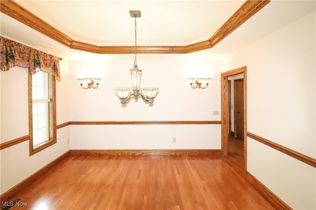 5280 Kapok Dr, Medina, OH 44256 - empty room with a raised ceiling, a chandelier, wood finished floors, healthy amount of natural light, and crown molding
