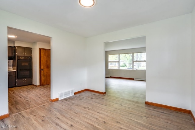 1924 Tiffany Dr NE, Warren, OH 44483 - unfurnished room featuring baseboards, a baseboard radiator, and light wood-style flooring
