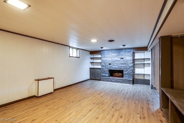 1924 Tiffany Dr NE, Warren, OH 44483 - unfurnished living room with a stone fireplace, light wood-style floors, and baseboards
