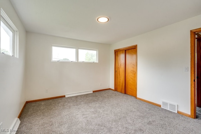 1924 Tiffany Dr NE, Warren, OH 44483 - unfurnished bedroom with baseboard heating, carpet, a closet, and baseboards