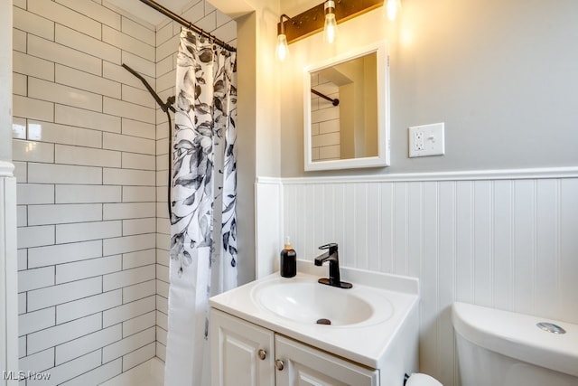 1924 Tiffany Dr NE, Warren, OH 44483 - bathroom with toilet, a tile shower, vanity, and a wainscoted wall