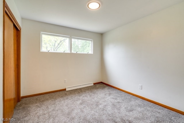 1924 Tiffany Dr NE, Warren, OH 44483 - unfurnished bedroom with baseboard heating, carpet flooring, a closet, and baseboards