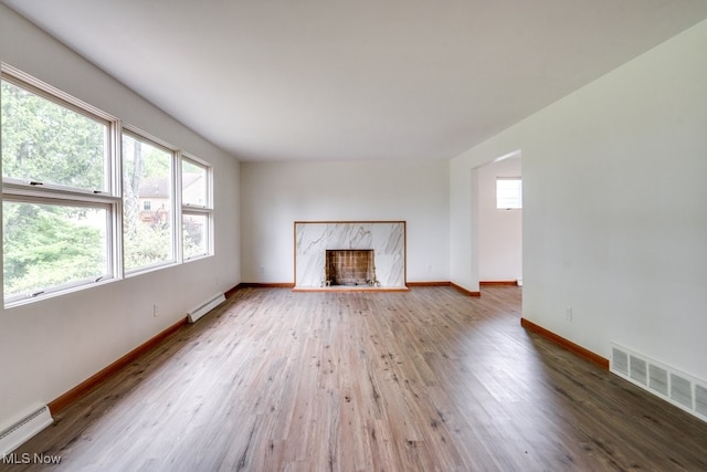 1924 Tiffany Dr NE, Warren, OH 44483 - unfurnished living room featuring a baseboard heating unit, a baseboard radiator, wood finished floors, baseboards, and a premium fireplace