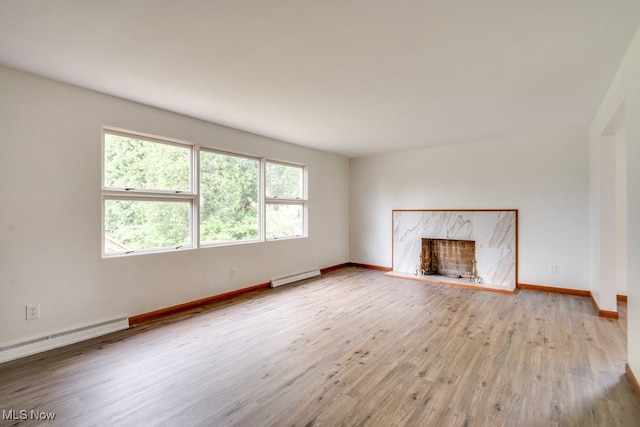 1924 Tiffany Dr NE, Warren, OH 44483 - unfurnished living room featuring baseboard heating, wood finished floors, a premium fireplace, a baseboard heating unit, and baseboards