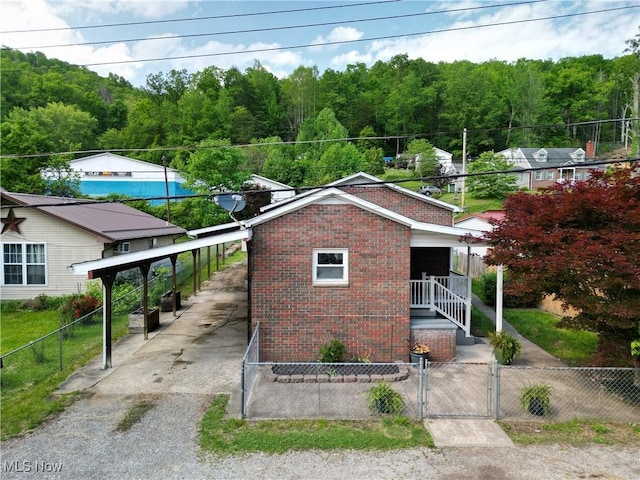 231 Center St, Clay, WV 25043 - ranch-style house with brick siding, a gate, driveway, and a wooded view
