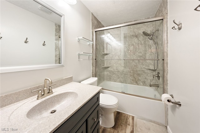 36304 Westfield Dr, North Ridgeville, OH 44039 - bathroom with toilet, vanity, a textured ceiling, wood finished floors, and bath / shower combo with glass door