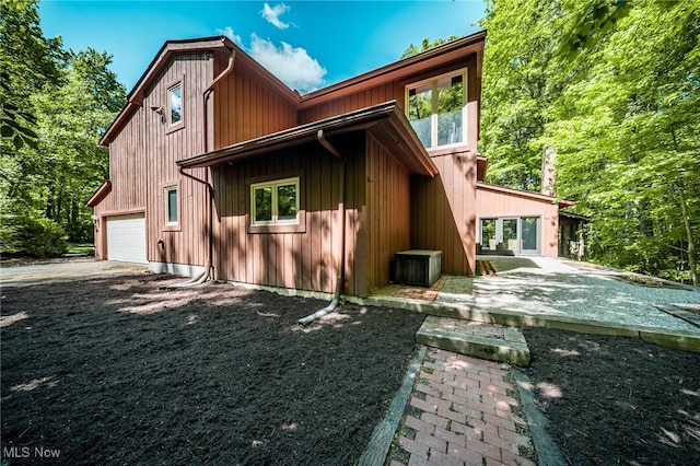 10576 Hemlock Ridge Dr, Chardon, OH 44024 - rear view of house featuring a garage, board and batten siding, and driveway