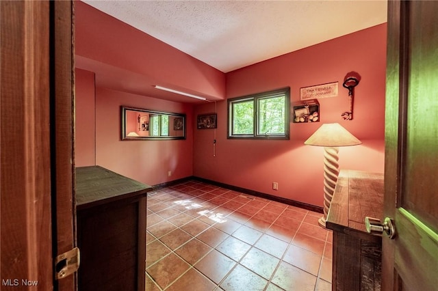 10576 Hemlock Ridge Dr, Chardon, OH 44024 - empty room featuring tile patterned flooring, a textured ceiling, and baseboards