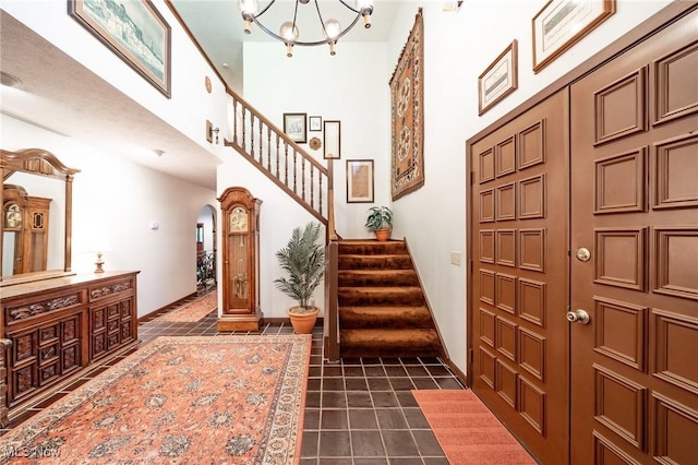 10576 Hemlock Ridge Dr, Chardon, OH 44024 - foyer featuring arched walkways, baseboards, stairs, a towering ceiling, and dark tile patterned floors
