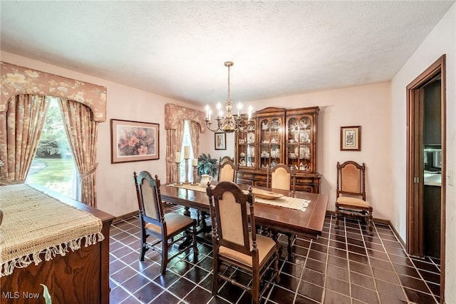 10576 Hemlock Ridge Dr, Chardon, OH 44024 - dining room featuring a chandelier, a textured ceiling, dark tile patterned floors, and baseboards