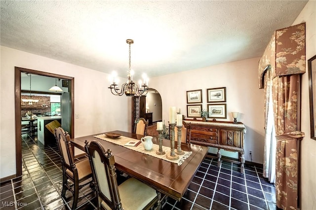 10576 Hemlock Ridge Dr, Chardon, OH 44024 - dining room with arched walkways, a chandelier, a textured ceiling, and tile patterned floors