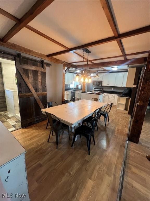 26938 County Rd 1, Coshocton, OH 43812 - dining space with a barn door, coffered ceiling, wood finished floors, and beamed ceiling