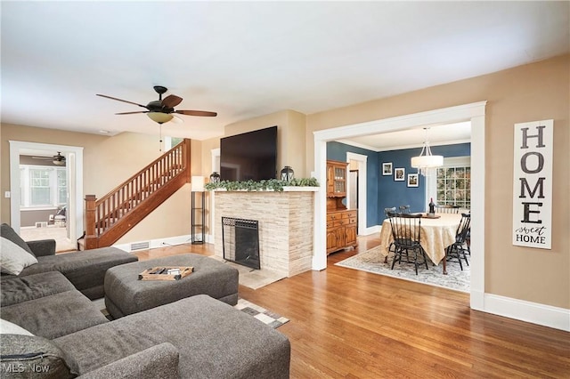 4531 Ardendale Rd, South Euclid, OH 44121 - living area featuring ceiling fan, wood finished floors, stairway, a stone fireplace, and baseboards