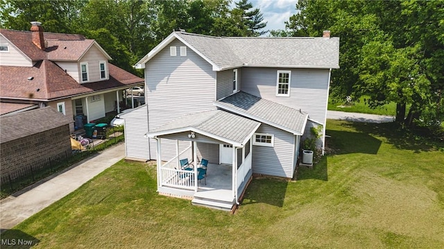 back of house featuring a yard, central AC, and a chimney