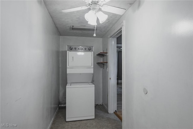 laundry room featuring stacked washer / drying machine, ceiling fan, and baseboards